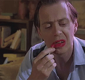 A Man Is Applying Red Lipstick To His Lips And Making A Funny Face . GIF