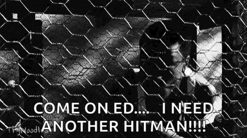 A Man Is Behind A Chain Link Fence And Says `` Come On Ed ... I Need Another Hitman !! '' GIF