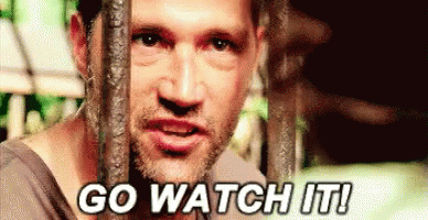 A Man Is Behind Bars With The Words `` Go Watch It '' Written On His Face . GIF