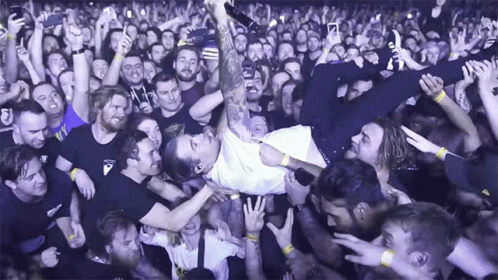 A Man Is Being Lifted Up In The Air By A Crowd Of People GIF