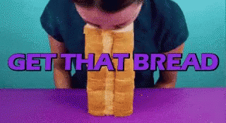 A Man Is Biting Into A Loaf Of Bread With The Words Get That Bread Written Above Him GIF