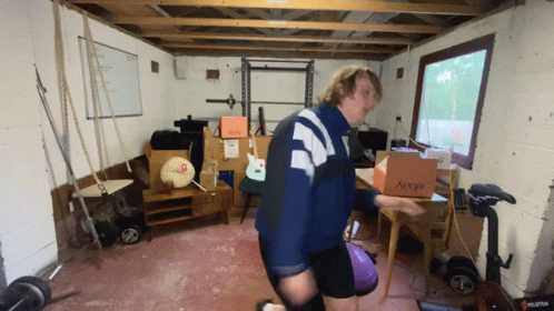 A Man Is Carrying A Box That Says Aeocd On It GIF