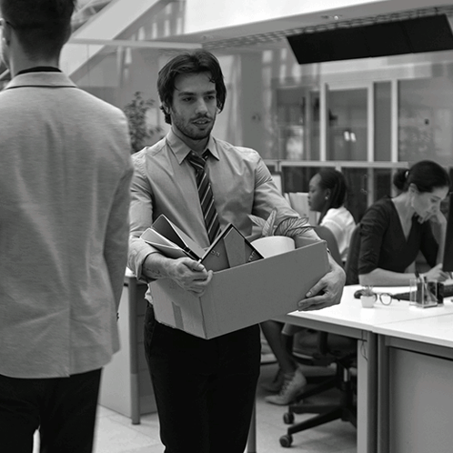 a man is carrying a cardboard box with his belongings
