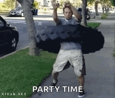 A Man Is Carrying A Large Black Bag On His Shoulders While Standing On A Sidewalk . GIF