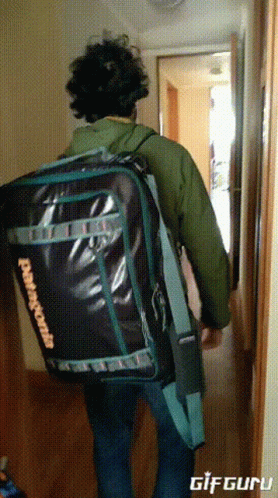 A Man Is Carrying A Large Patagonia Bag GIF