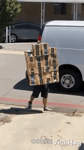 A Man Is Carrying A Stack Of Boxes On His Back And Says Oopsie Viralhog On The Bottom GIF