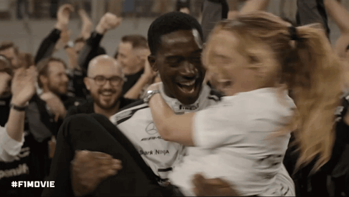 A Man Is Carrying A Woman In His Arms And The Hashtag #Fimovie Is Visible In The Corner GIF