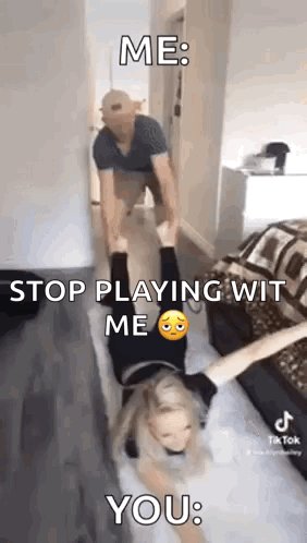 A Man Is Carrying A Woman Upside Down On His Shoulders In A Room . GIF