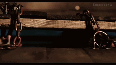 A Man Is Chained To A Wooden Plank With A X On The Bottom Right GIF
