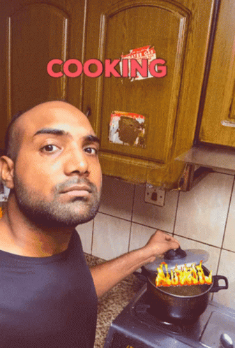 A Man Is Cooking In Front Of A Cabinet That Says Cooking On It GIF