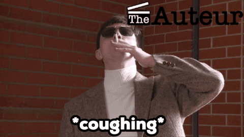 A Man Is Coughing In Front Of A Brick Wall With The Authors Logo GIF