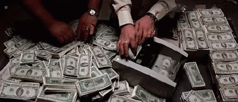 A Man Is Counting Money On A Table . GIF