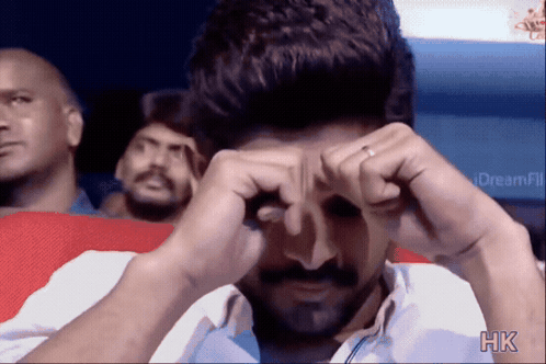 A Man Is Covering His Eyes With His Hands And The Letters Hk Are On The Bottom Right GIF