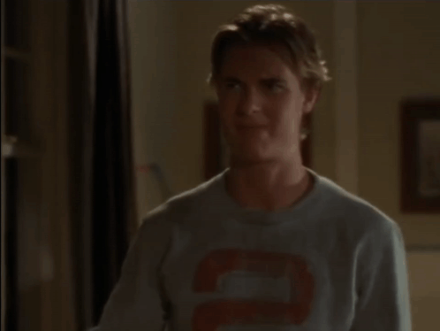 A Man Is Covering His Face With His Hand In A Room GIF