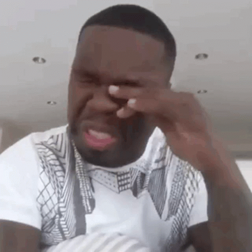 A Man Is Covering His Face With His Hand While Crying . GIF