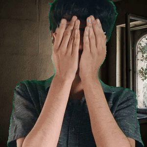 A Man Is Covering His Face With His Hands GIF