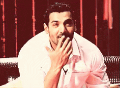 A Man Is Covering His Mouth With His Hand GIF