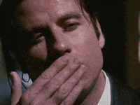 Man Covering Mouth Talking On Phone GIF