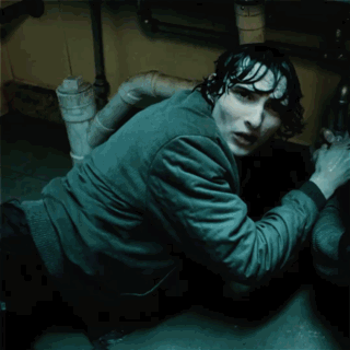 A Man Is Crawling Under A Sink With The Words " Are You By " Glowing On His Shirt GIF