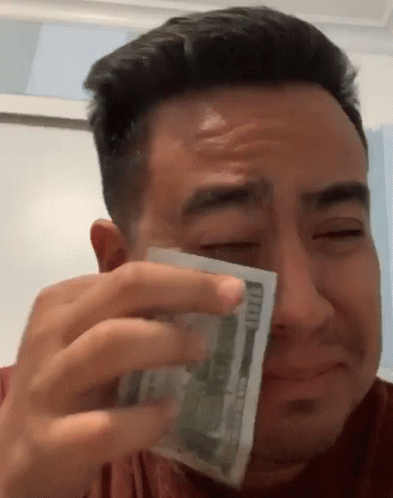 A Man Is Crying While Holding A Stack Of 100 Dollar Bills GIF