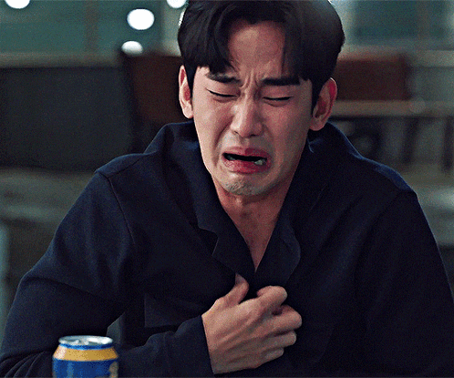 A Man Is Crying While Holding His Chest And A Can Of Beer Is In Front Of Him GIF