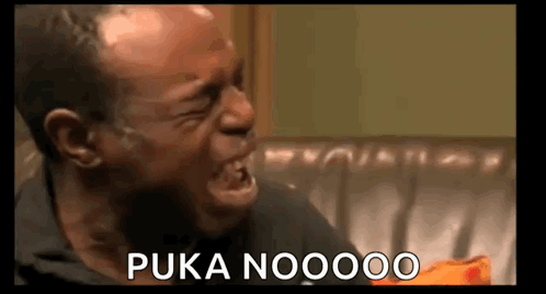 a man is crying while sitting on a couch and saying puka noooo .