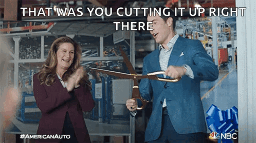 Man Cutting Ribbon While Woman Applauds GIF