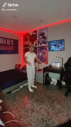 A Man Is Dancing In A Bedroom With A Sign That Says Otos GIF