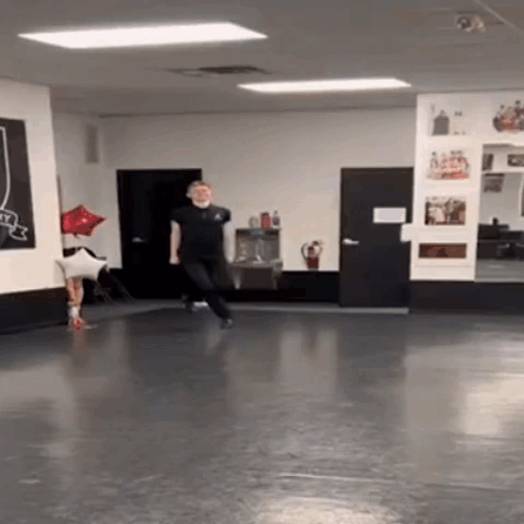 A Man Is Dancing In A Dance Studio With A Red Balloon In The Background . GIF