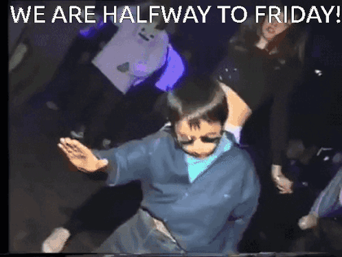 A Man Is Dancing In A Dark Room With The Words We Are Halfway To Friday GIF