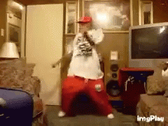 A Man Is Dancing In A Living Room With A Microphone In His Hand GIF