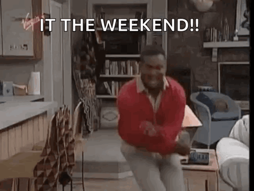 A Man Is Dancing In A Living Room With The Words `` It The Weekend '' Written On The Screen . GIF