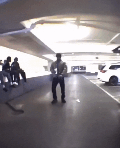 A Man Is Dancing In A Parking Garage GIF