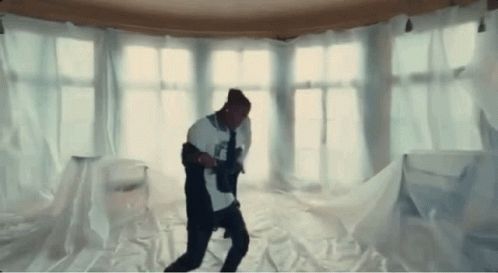 A Man Is Dancing In A Room Covered In White Cloth GIF