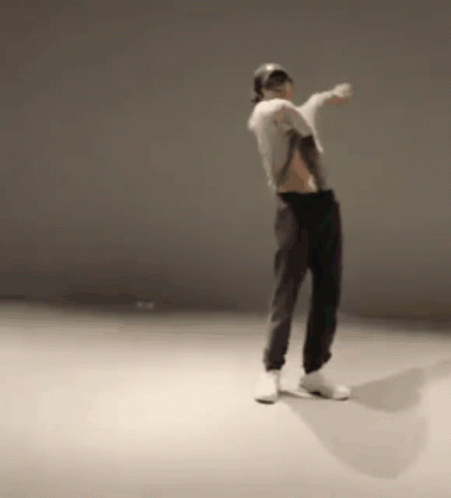 A Man Is Dancing In A Room With A Hat On . GIF
