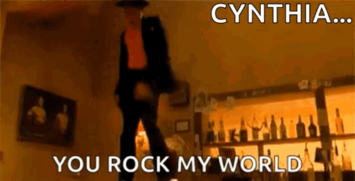A Man Is Dancing In A Room With The Words Cynthia You Rock My World Written Above Him GIF
