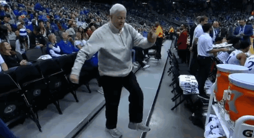 A Man Is Dancing In A Stadium With A Gatorade Cooler In The Background GIF