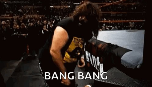 A Man Is Dancing In A Wrestling Ring With The Words `` Bang Bang '' Written On The Bottom . GIF