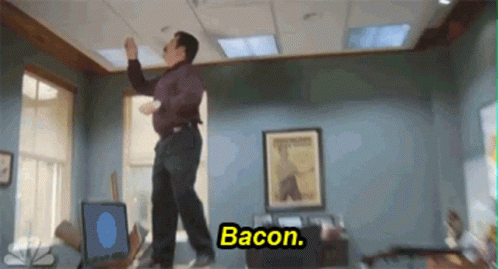 A Man Is Dancing In An Office With The Words Bacon Written On The Bottom GIF