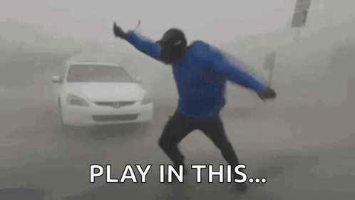 A Man Is Dancing In Front Of A Car In A Foggy Street . GIF