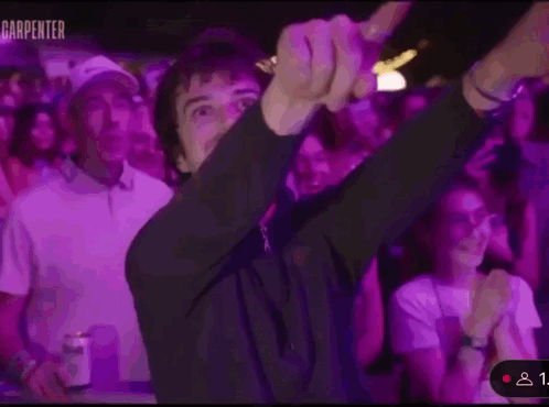 A Man Is Dancing In Front Of A Crowd Of People At A Party . GIF