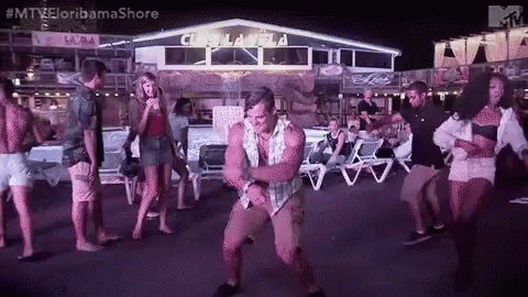 a man is dancing in front of a group of people at a party .