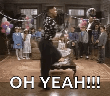 A Man Is Dancing In Front Of A Microphone In A Living Room While A Group Of Children Watch . GIF