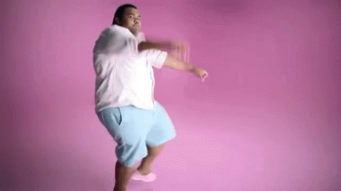 A Man Is Dancing In Front Of A Pink Background . GIF