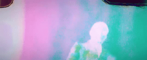 A Man Is Dancing In Front Of A Pink Wall In A Room . GIF