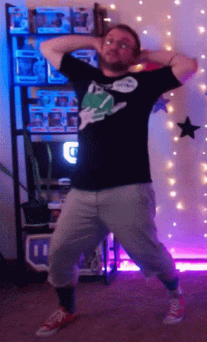 A Man Is Dancing In Front Of A Shelf Full Of Funko Pops GIF