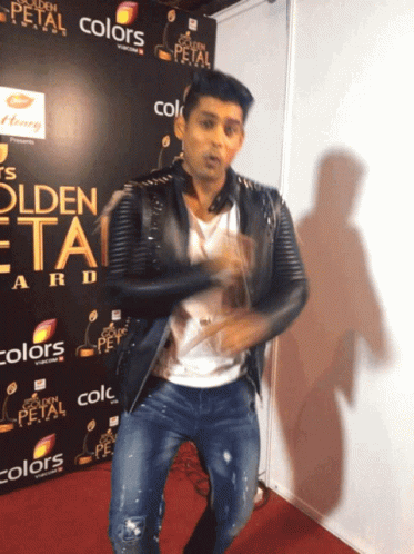 A Man Is Dancing In Front Of A Sign That Says Golden Petal GIF