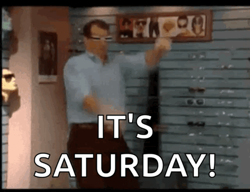 A Man Is Dancing In Front Of A Sign That Says " It 'S Saturday " GIF