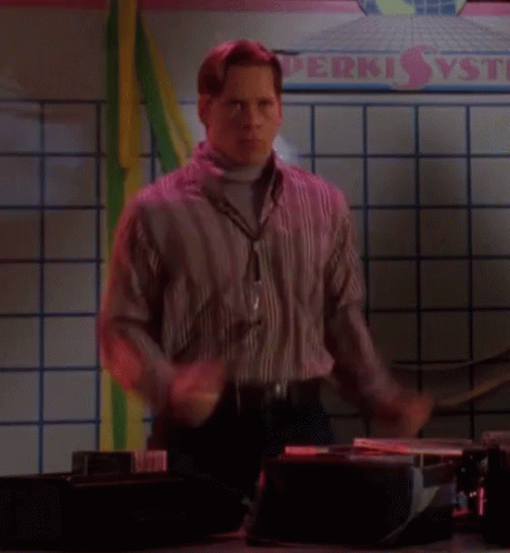 A Man Is Dancing In Front Of A Sign That Says Perki GIF