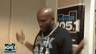 A Man Is Dancing In Front Of A Sign That Says Power 105.1 GIF
